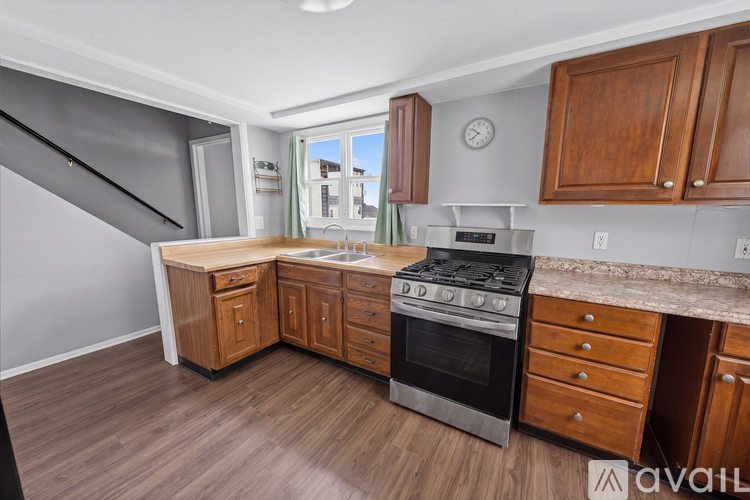 A kitchen with wooden cabinets and a stainless steel stove.