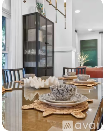 A modern dining room with a wooden table set for a meal.