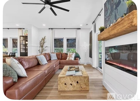 A living room with a brown leather couch and a wooden coffee table.