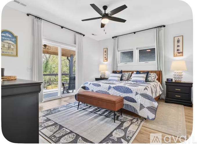 A bedroom with a bed, nightstand, and a ceiling fan.