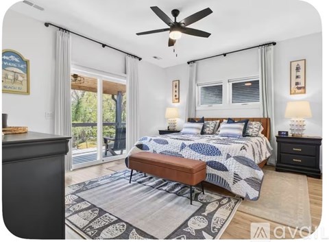 A bedroom with a bed, nightstand, and a ceiling fan.