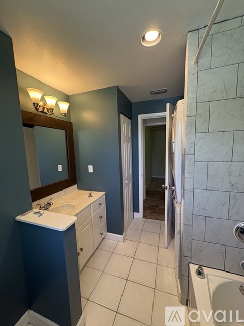 A bathroom with a white sink and a mirror above it.