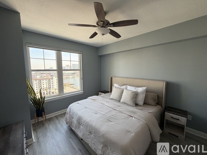 A bedroom with a large bed and a ceiling fan.