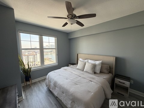 A bedroom with a large bed and a ceiling fan.