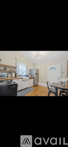 A kitchen with a refrigerator, sink, and cabinets.