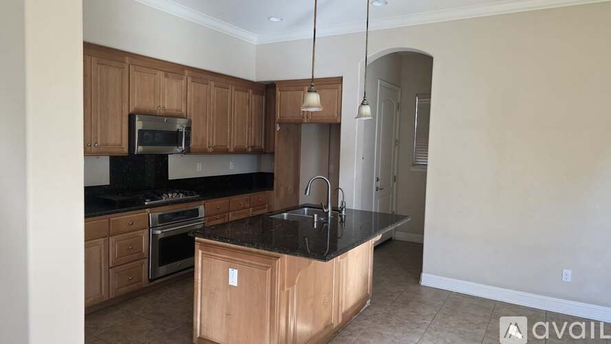 A kitchen with wooden cabinets and black countertops.