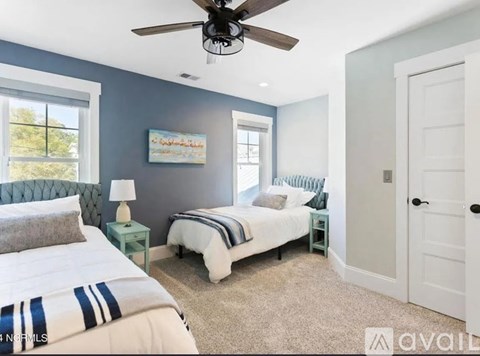 A bedroom with a large bed and a ceiling fan.