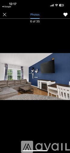 A living room with a grey sofa and a television on the wall.