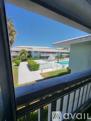 A balcony view of a pool and apartment building.
