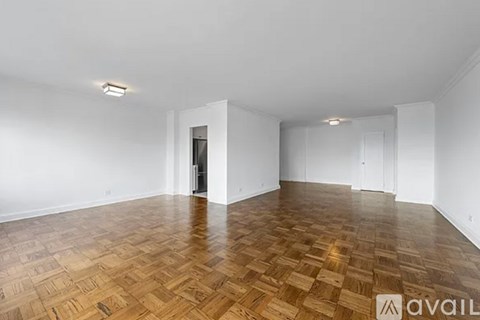 A room with wooden flooring and white walls.