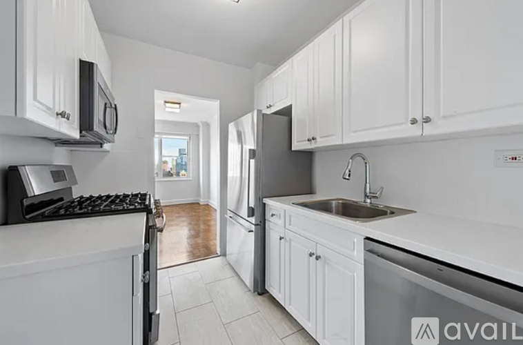 A kitchen with white cabinets and appliances.