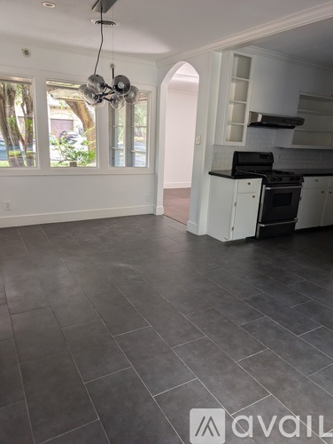 A kitchen with a black stove top oven and white cabinets.