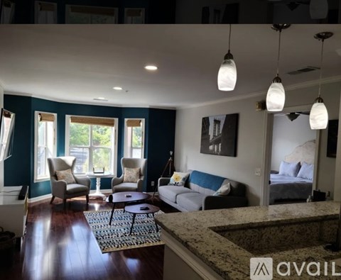 A living room with a sofa, chairs, and a rug.