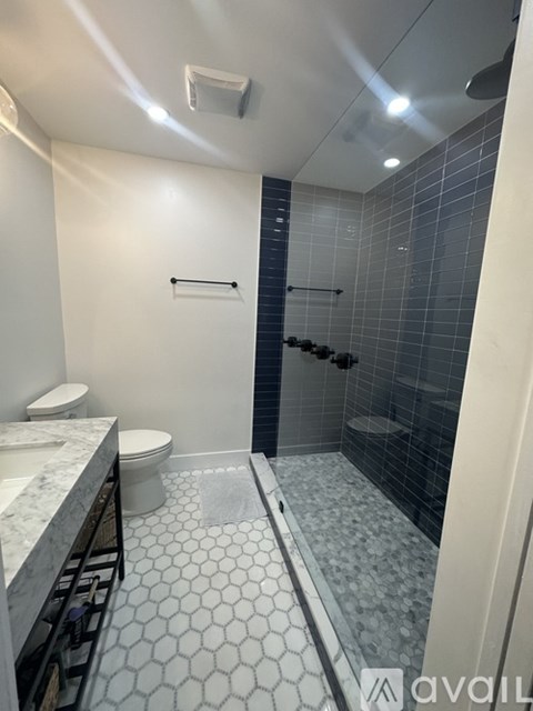 A bathroom with a toilet, sink, and shower.