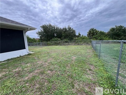 A backyard with a fence and a shed.