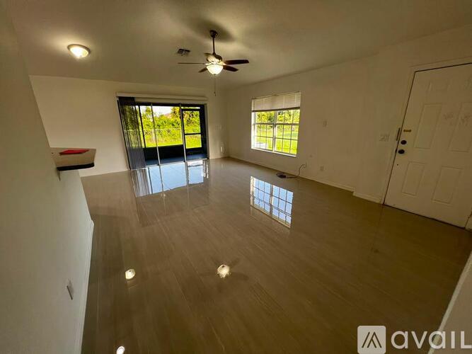 A spacious room with wooden flooring and a ceiling fan.