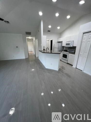 A spacious kitchen with white cabinets and a large island.