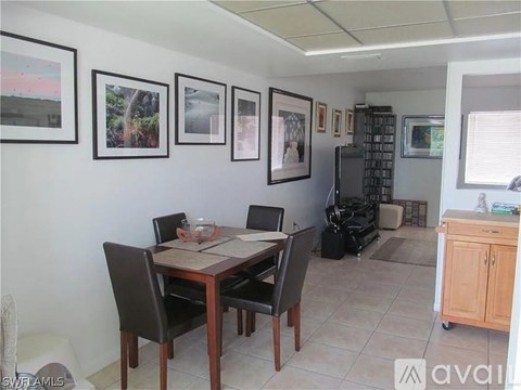 A dining room with a table and chairs and pictures on the wall.