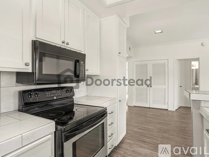 A modern kitchen with black appliances and white cabinetry.