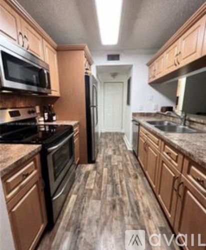 A kitchen with wooden cabinets and a black stove top oven.