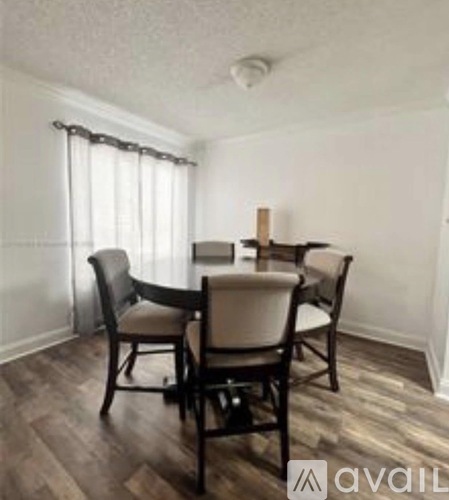 A dining room with a table and chairs.