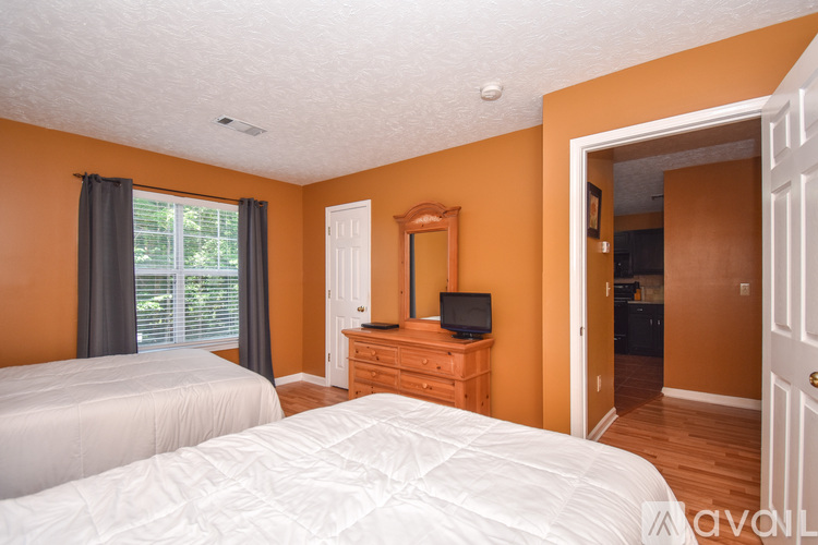 A bedroom with a bed, dresser, and mirror.