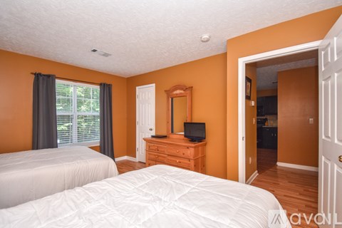 A bedroom with a bed, dresser, and mirror.