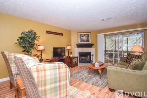 A living room with a fireplace and two chairs.