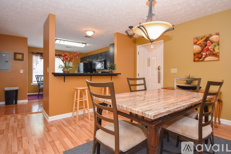 A kitchen with a table and chairs in the foreground.