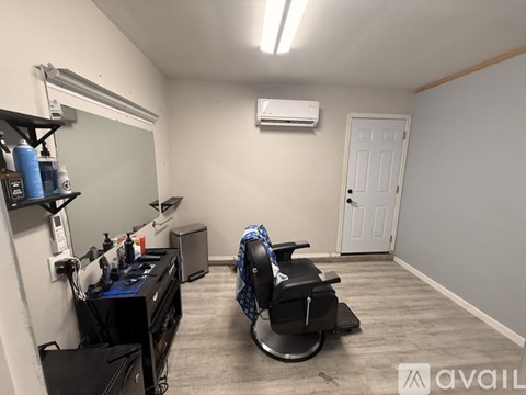 A room with a hair salon chair and a mirror.