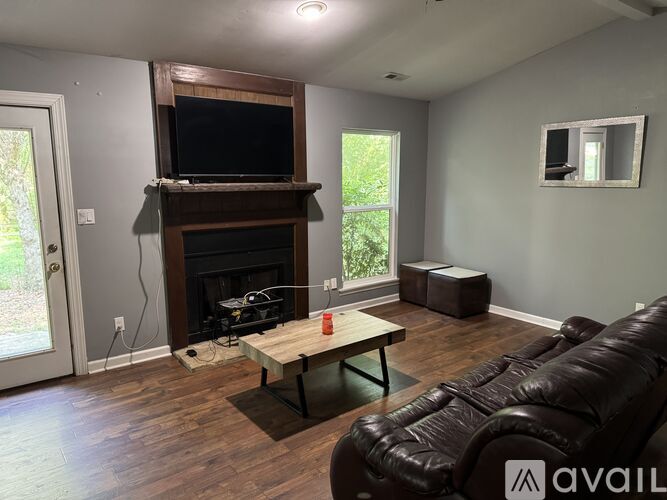 A living room with a fireplace and a television above it.