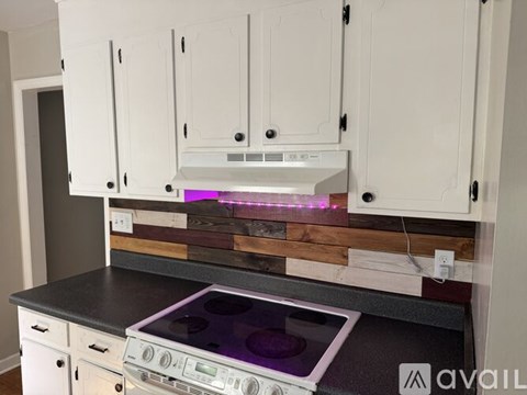 A kitchen with white cabinets and a stove top oven.