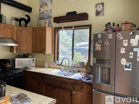 A kitchen with wooden cabinets and a stainless steel refrigerator.