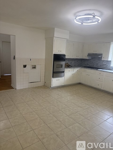 A kitchen with white cabinets and a tiled floor.