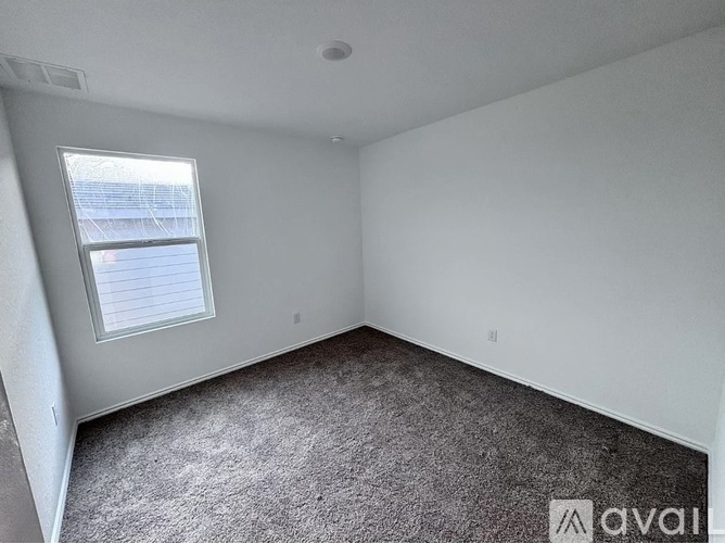 A room with a window and carpeted floor.