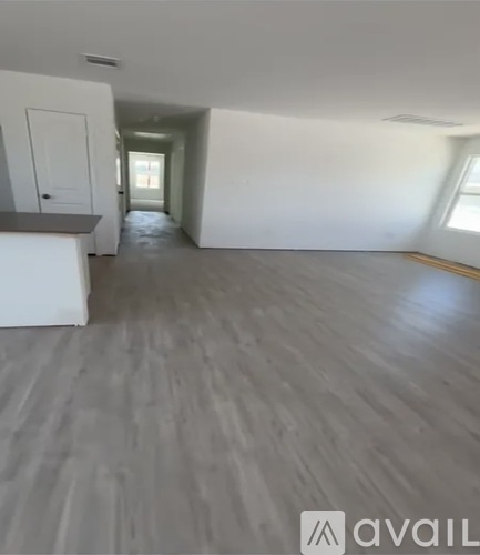 A spacious room with a grey floor and white walls.