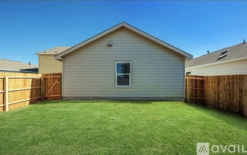 A house with a fence and a green lawn.