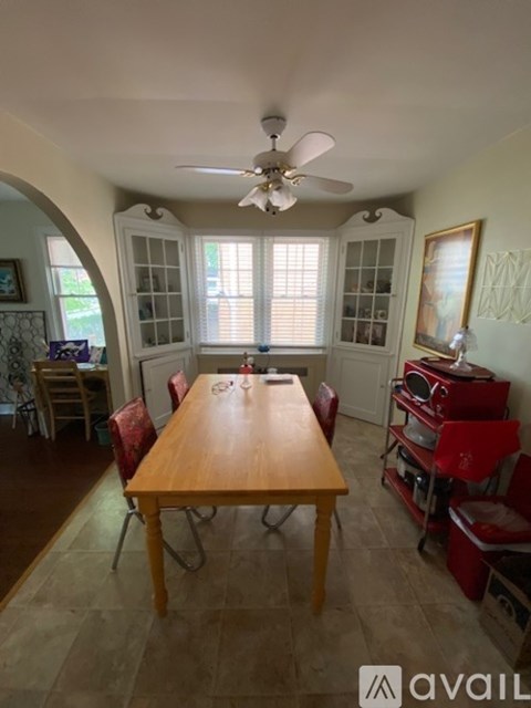 A dining room with a wooden table and chairs.