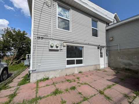 A house with a grey siding and a white door is shown.