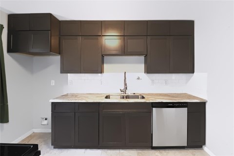 A kitchen with brown cabinets and a white dishwasher.