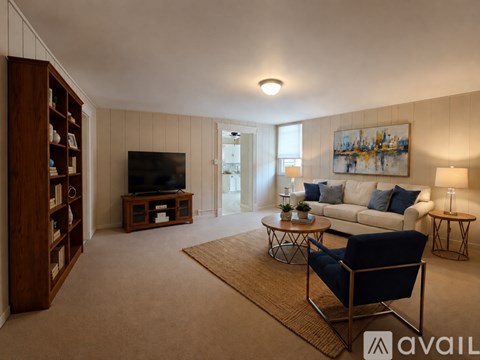 A living room with a blue chair and a television.