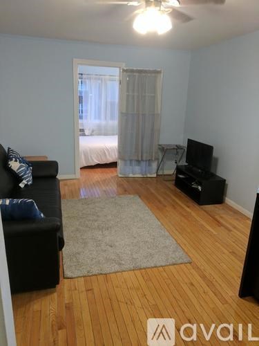 A living room with a black couch and a television.