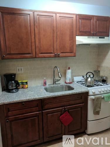 A kitchen with brown cabinets and a white stove.