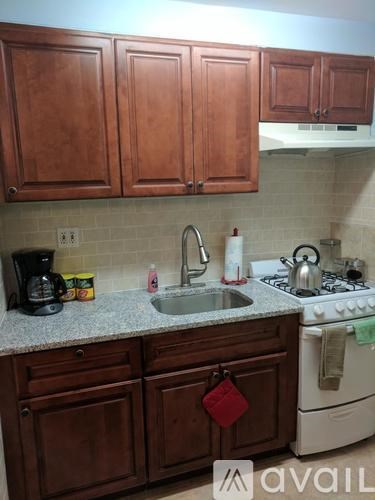 A kitchen with brown cabinets and a white stove.