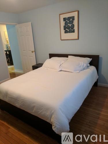 A bed with white sheets and two white pillows in a room.