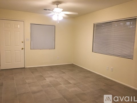 A room with a ceiling fan and a window with blinds.