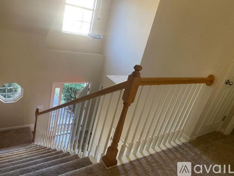 A staircase with a wooden handrail and white balusters.