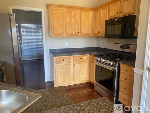 A kitchen with wooden cabinets and a black stove top oven.