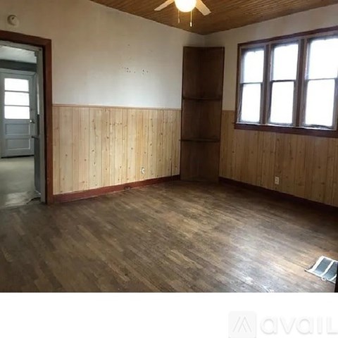 A room with wooden floors and a ceiling fan.