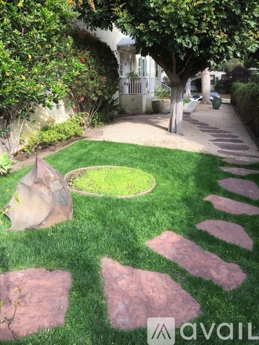 A garden pathway with stepping stones and a circular grass area.